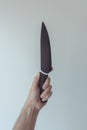 Male hand holding large ceramic kitchen knife