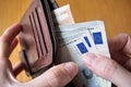 Male hand holding a leather wallet and withdrawing European currency (Euro, EUR) Royalty Free Stock Photo