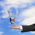 Male hand holding lightbulb with wind turbines inside Royalty Free Stock Photo