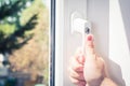 Male Hand Holding A Lockable Window Handle Of A Closed White Window With Trees In Background, Prevent Burglary Concept Royalty Free Stock Photo