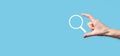 Male hand holding magnifying glass ,search icon on blue background. Concept search engine optimization, customer support.Browsing Royalty Free Stock Photo
