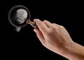 Hand Holding Magnifying Glass Viewing A Fingerprint on a Black Background