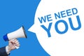 Male hand holding a megaphone with WE NEED YOU bubble. Speaker. Banner for business, marketing and advertising
