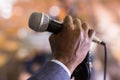 Male hand holding microphone at conference hall Royalty Free Stock Photo