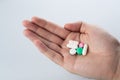 Male hand holding multicolor pills in hand on grey background, taking Your medication.