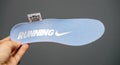 Male hand holding new running Nike shoe sole in blue color