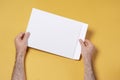 Male hand holding an A4 paper envelope,  mock-up template for design Royalty Free Stock Photo