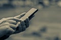 Male hand holding the phone.Blurred background, looking at the internet. Royalty Free Stock Photo