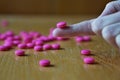 Male hand holding a pink pill as a symbol of pharmacy Royalty Free Stock Photo