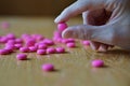 Male hand holding a pink pill as a symbol of pharmacy Royalty Free Stock Photo