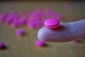 Male hand holding a pink pill as a symbol of pharmacy Royalty Free Stock Photo