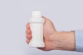 Male hand holding plastic bottle of pills. Close up. Copy space. Template. Mockup Royalty Free Stock Photo