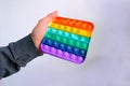 Male hand holding a rainbow Toy antistress Pop it, press rubber bubbles, concept entertainment, stress relief, development of fine