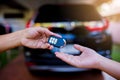 Male hand holding a remote car key and handing it over to give a Royalty Free Stock Photo