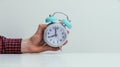 Retro styled white alarm clock in manÃ¢â¬â¢s hand,