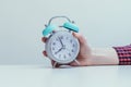 Retro styled white alarm clock in manÃ¢â¬â¢s hand, 