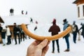 Sausage in hand with silhouettes of people in background