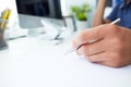 Male hand holding silver pen ready to make note in paper sheet. Royalty Free Stock Photo