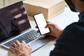 Business man holding smartphone with mock up screen at work desk. Royalty Free Stock Photo