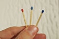 Male hand holding three safety matches, each with a different color of its top as a symbol of challenging choice and option