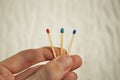 Male hand holding three safety matches, each with a different color of its top as a symbol of challenging choice and option