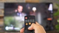 Male hand holding the TV remote control and changing TV channels Royalty Free Stock Photo