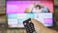 Male hand holding the TV remote control and changing TV channels Royalty Free Stock Photo