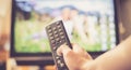 Male hand is holding TV remote control, streaming on a smart TV Royalty Free Stock Photo