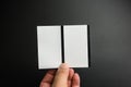 Male hand holding two blank sheets of paper tickets