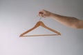 Male hand holding wooden cloth hanger