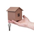 Male hand holding a wooden house model and keys isolated on white background with copy space. Real estate agent concept Royalty Free Stock Photo