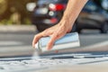 Male hand holds an aerosol can with white paint. Surface painting, graffiti on the street Royalty Free Stock Photo