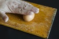 A male hand holds a boiled chicken egg in his shell against the chopping board Royalty Free Stock Photo