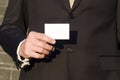 Male hand holds a business card. make contact. give your data, presentation. a man in a business suit shows a credit card Royalty Free Stock Photo