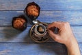 Male hand holds a cup of black coffee with foam in the shape of a heart and vanilla muffins on a background of blue wooden table Royalty Free Stock Photo