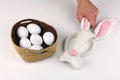 Male hand holds ear of mask of Easter Bunny, white background