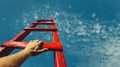 Development Attainment Motivation Career Growth Concept. Mans Hand Reaching For Red Ladder Leading To A Blue Sky Royalty Free Stock Photo