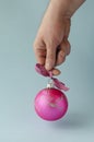 Male hand holds pink Christmas ball