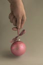 Male hand holds pink Christmas ball