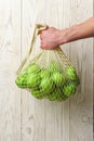 Male hand holds a string bag with green apples Royalty Free Stock Photo