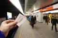 Male hand holds two tickets in subway