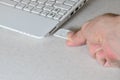 A male hand inserts a white compact SD card into the corresponding input in the side of the white netbook. Man uses modern techno