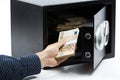 Male hand keeping euro banknotes in a safe deposit box