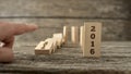 Male hand knocking down a line of domino with the first one hold