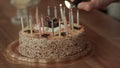 Male hand lighting candles in birthday cake