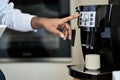 Male hand making coffee in machine in cafe or office. Close up Royalty Free Stock Photo