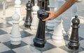 Man playing big chess outdoors. Male hand making a move while playing big chess game on the ground. . Strategy or decision concept Royalty Free Stock Photo