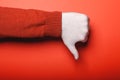 Male hand in medical glove shows thumb down on red background Royalty Free Stock Photo