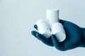 A male hand in medical gloves holds in his palm a handful of bottles of pills Royalty Free Stock Photo