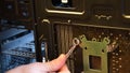 Male hand with metal wrench fix nut on bolt at computer motherboard